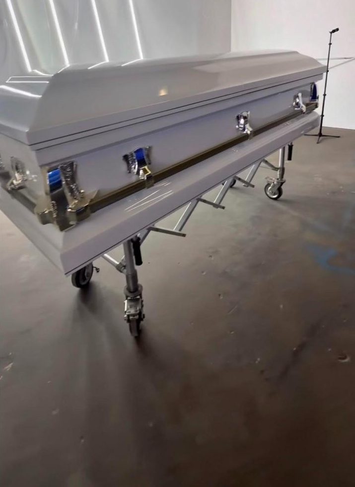 A plain white casket on a church truck in the Suave Wraps shop before wrapping